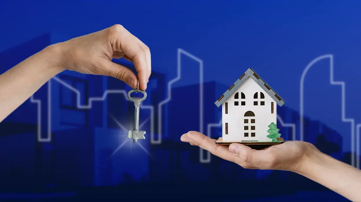 Hands exchanging a house key above a miniature white house model on blue background.